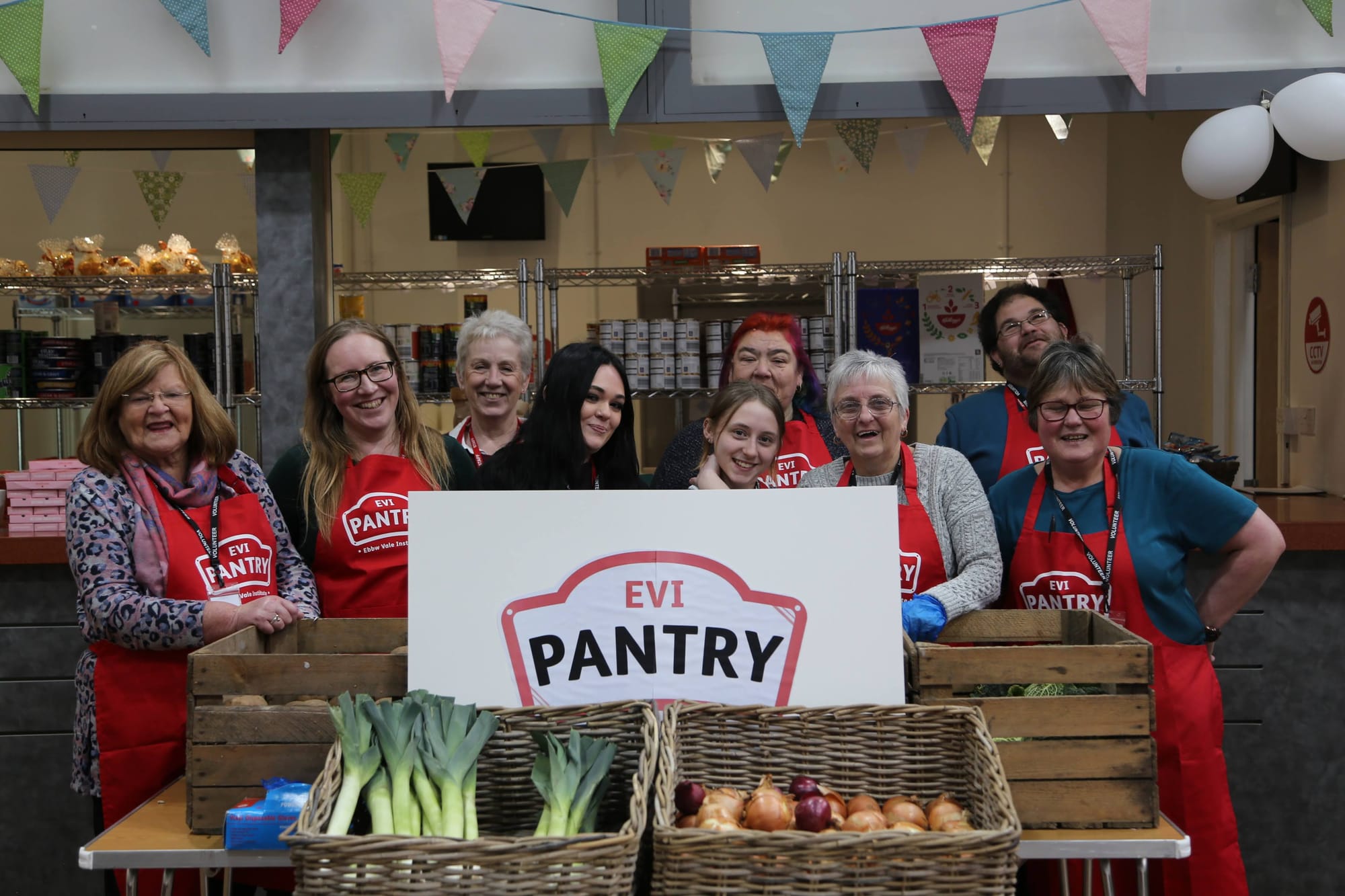 Smiling group photo of EVI Pantry team in the Pantry.