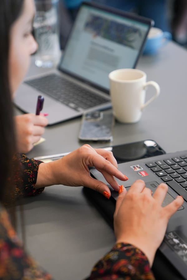 Two women on laptops at a training session